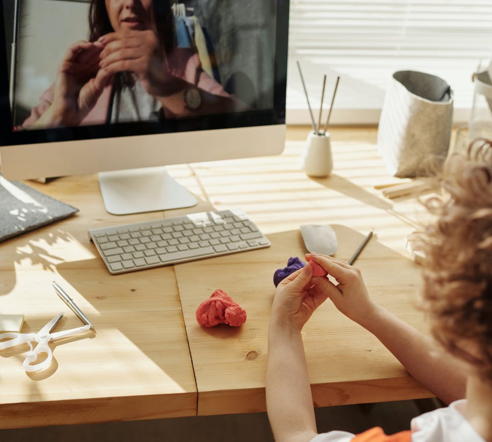 Photo Of Kid Playing With Clay While Looking In The Monitor