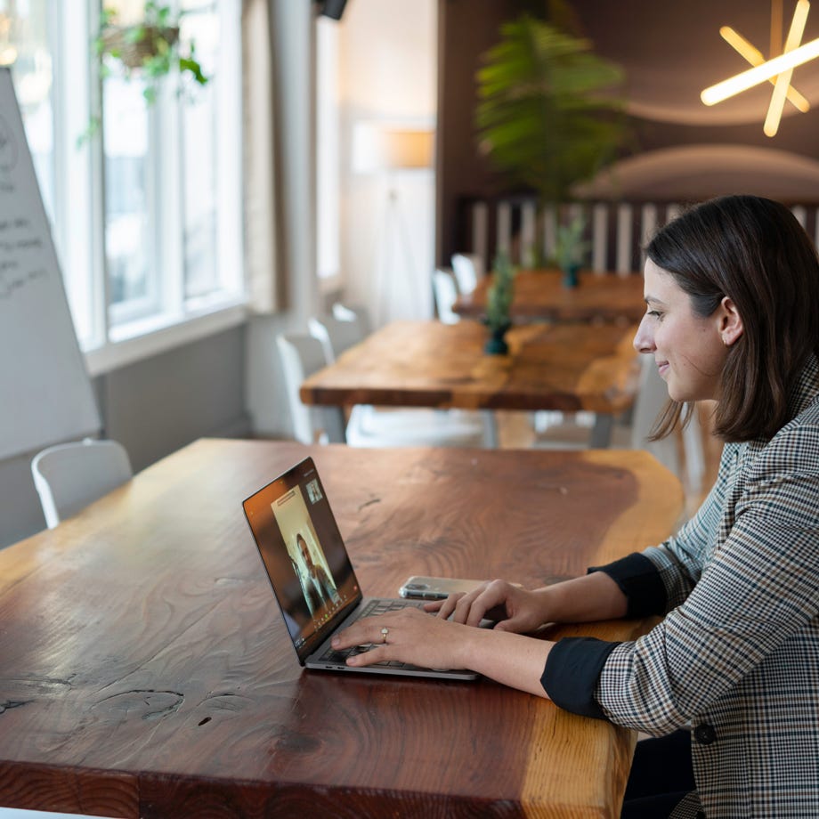 A Woman in Plaid Long Sleeves Using a Laptop